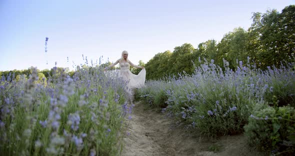 Cinematic View of Woman Dancing Colorful Lavender Fields on a Sunny Day Blooming Purple Flowers. alt
