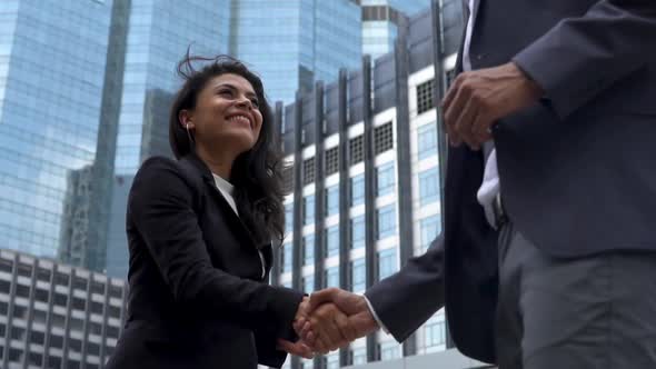 Slow motion of successful young smiling businesswoman talking and shaking hands