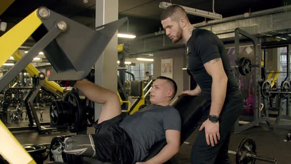 Young Man with Prosthetic Leg Using Leg Press Machine in Gym