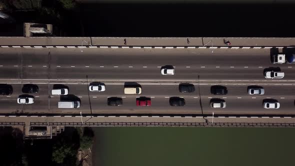 Drone's Eye View Aerial Top Down View Of Traffic Driving Over A Modern Bridge alt