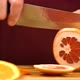 Man's hand is slicing grapefruit on wooden board.  - VideoHive Item for Sale