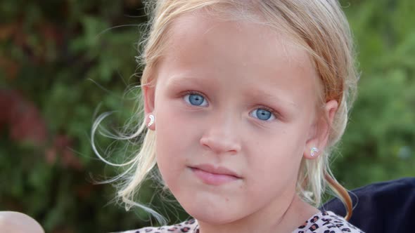 Outdoor Portrait of Lovely Little Girl with Blue Eyes alt