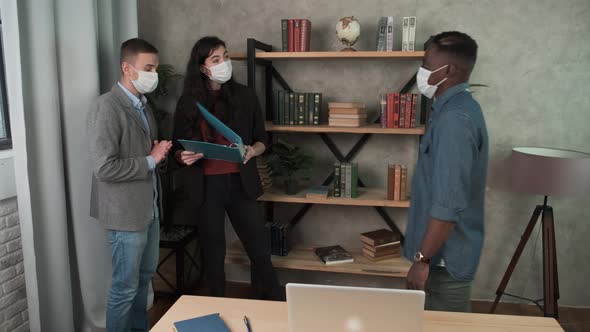 Colleagues Avoid a Handshake When Meeting in the Office and Greet Bumping Elbows. Multi-ethnic alt