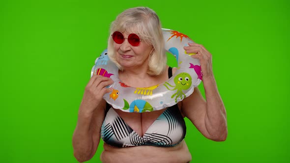 Elderly Woman Tourist in Swimsuit Dancing Celebrating Smiling with Rubber Ring on Chroma Key alt