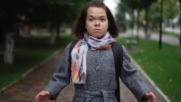 Zoom in and Out of Disturbed Unhappy Little Person Covering Ears with Hands Standing Outdoors on alt