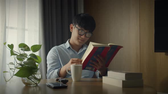Young Attractive Asian Vietnamese Man is Busy Working Learning on Desk Book at Home Data Analyst alt