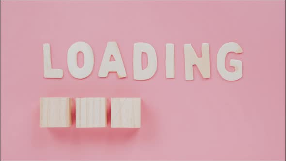Stop motion animation Loading process is shown in wooden box on pink blackground.