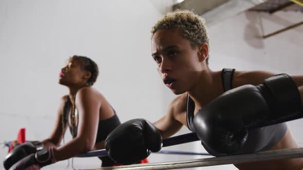 Two mixed race women resting after working out alt