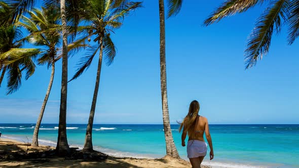 Woman under palm trees alt