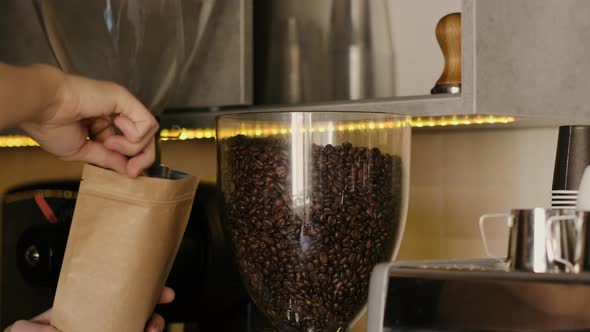 Barista putting fresh coffee beans in a craft bag in cafe it slow motion closeup with 4k. alt