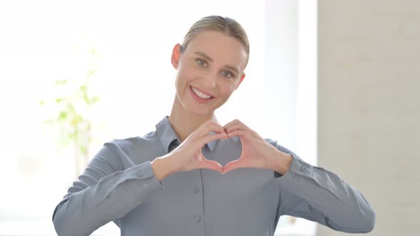 Portrait of Woman Showing Heart Shape By Hands alt