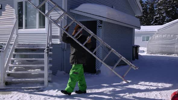 Removing Fresh Snow From a Roof in a Sunny Winter Day alt