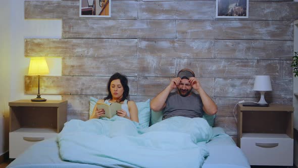 Woman Reading a Book Wearing Pajamas in Bedroom alt