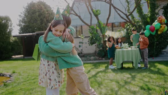 Birthday Girl Reacts at the Gift and Hugs a Friend at a Backyard Party