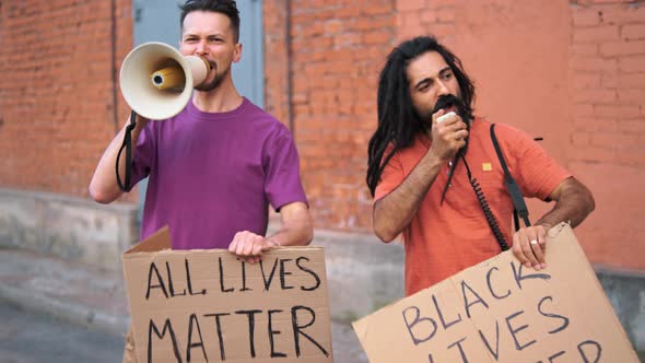 Two Caucasian Men are Protesting in the Street with Megaphones and Signs