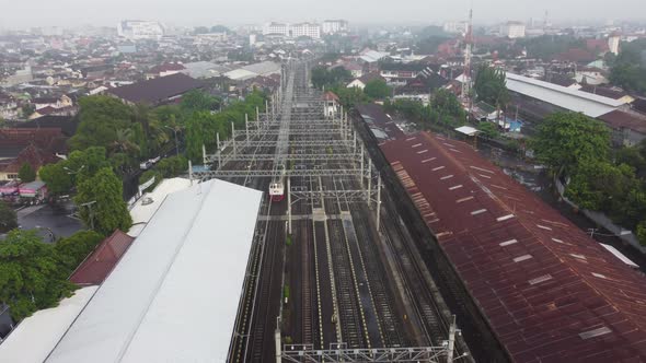 A drone flies over a train station. Aerial top view. The train is passing alt