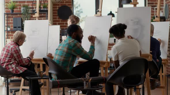 Young Students Drawing on Canvas and Talking About Artwork alt