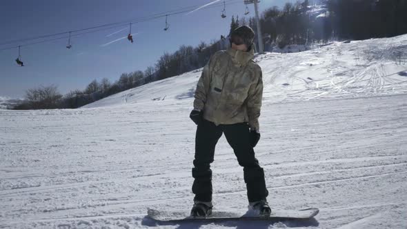 Snowboarder Enjoying a Mountain Ride at a Ski Resort on a Sunny Day