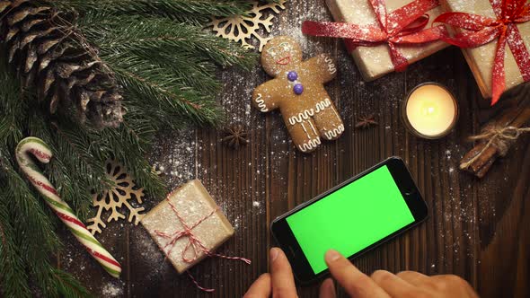 Look From Above Smartphone Green Screen Lying Among Christmas Cookies Fir Branches Present Packages alt