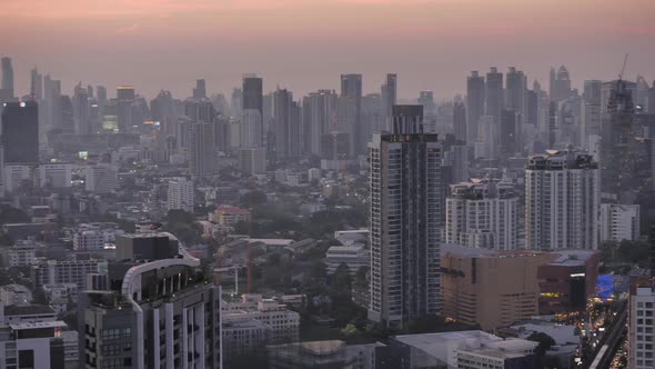 Panning view of business area in Bangkok, Thailand, showing buildings and traffic in twilight time alt