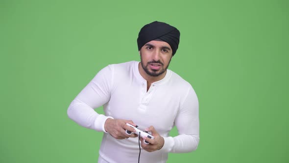 Young Stressed Bearded Indian Man Playing Games and Losing alt