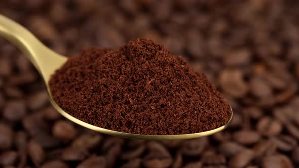 coffee. ground coffee in golden spoon and coffee beans on background rotate alt