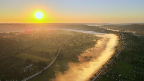 Aerial drone view of the Old Orhei at sunset. Valley with river and fog, village, monastery located  alt