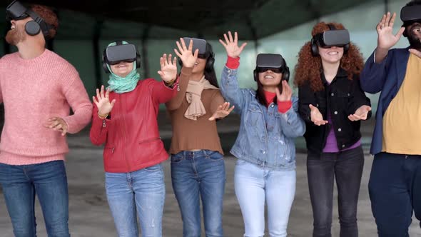 Young diverse people having fun using virtual reality goggles outdoor