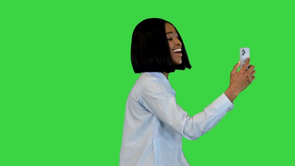 African Female Walk and Talk with Online Video Call Holding Smartphone Smiling Girl Speak on Mobile alt