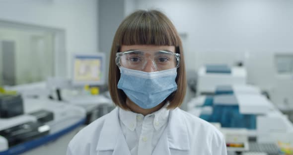 Portrait of Young Female Person in Protective Mask and Googles Looking To Camera alt