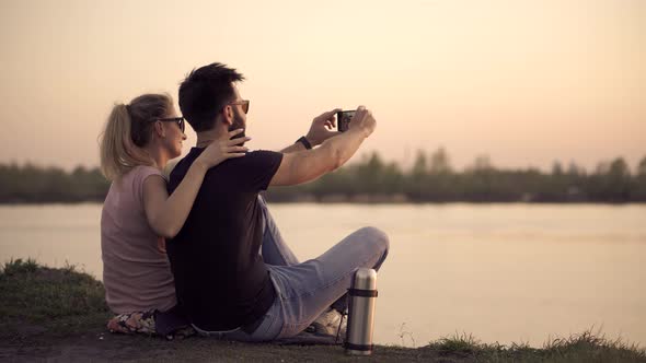 Couple Taking Selfie On Mobile Phone At Sunset. Silhouette Couple In Love Taking Selfie Smartphone. alt