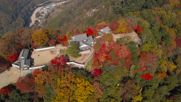 Rotating Aerial Drone over Bitchu Matsuyama Castle during autumn colors in Japan alt