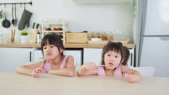 Asian two sweet sisters little girl enjoy eat fast food, potato chips. alt