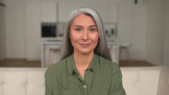 Headshot of Charming Grayhaired 50s Asian Woman Looking at the Camera