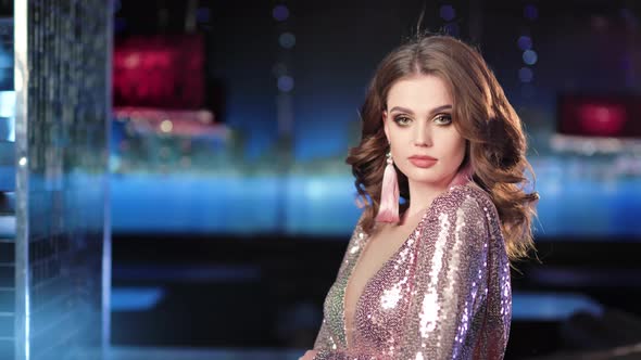 Beautiful Fashion Woman Wearing Glamour Dress with Glitter Posing in Lights and Flare Background alt