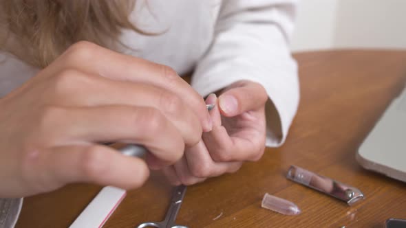 Closeup of a Young Caucasian Woman Doing a Manicure By Cutting Off Nails and Cuticles at Home alt