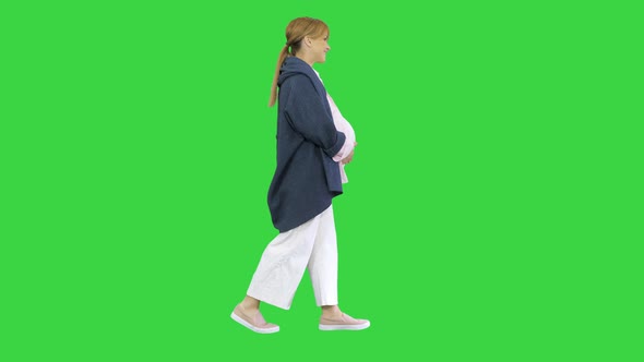 Happy Pregnant Blonde Lady Walking on a Green Screen, Chroma Key. alt