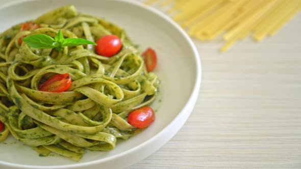 fettuccine spaghetti pasta with pesto sauce and tomatoes - vegan and vegetarian food style alt