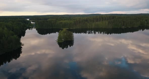 An island in the middle of a glassy lake during sunset alt