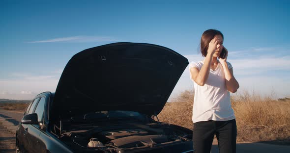 Young Woman in Front of Breakdown Car Using Smartphone Calling Service on Road alt
