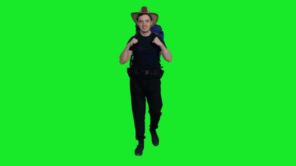 Young Smiling Adventurous Hiker in Cowboy Hat with Backpack Walking in Nature Against Green Screen