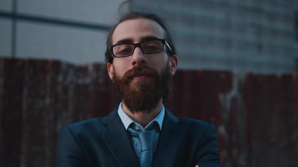 Young handsome  architect, he takes on his glasses and smiles towards the camera.