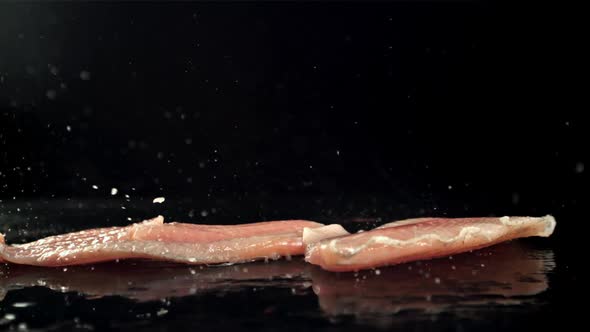 Fish Fillets Fall on the Table with Splashes of Water alt