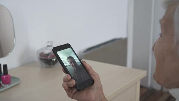 Old woman having video chat using smartphone