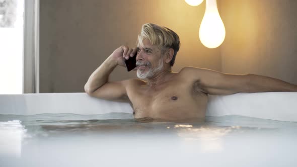 Man talking on smartphone in Jacuzzi
