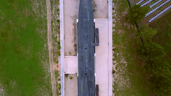 Aerial top down of oldsubmarine from military as exhibition during daytime alt