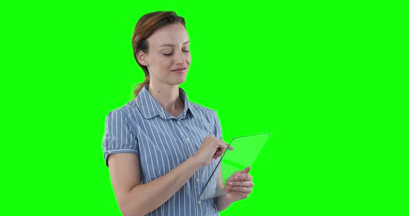 Caucasian woman holding a transparent screen on green background