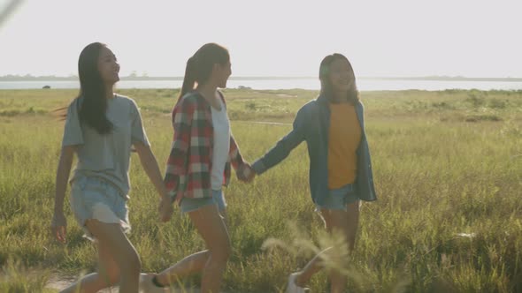 Asian women running while sunset having fun together a summer traveling.