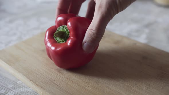 Man Cuts Red Pepper with Knife