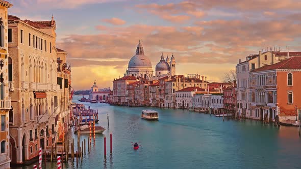 Boats and Gondolas Sail Along Wide Canal Among Buildings alt